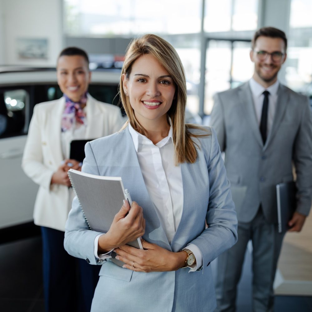 salesteam-in-dealership-three-beautiful-consultants-or-managers-in-elegant-suit-looking-on-camera-.jpg